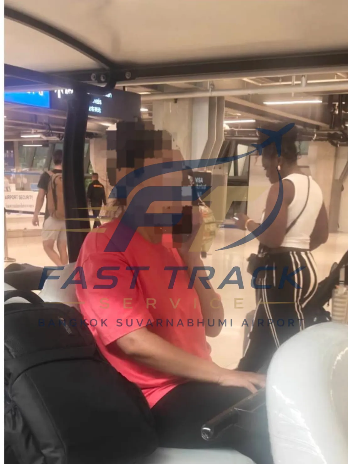 Traveller in an airport buggy while the greeter stands nearby